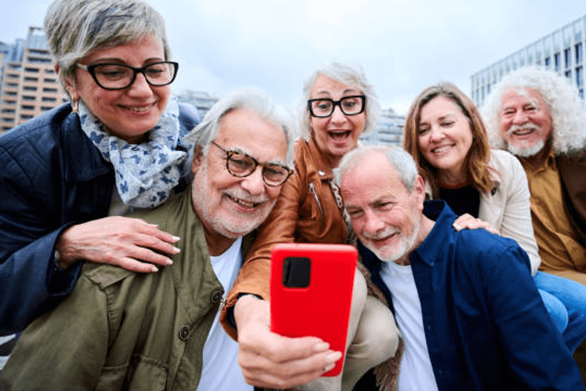 Gruppe von Menschen schaut auf rotes Smartphone